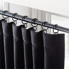 black curtains hanging on a metal rod in front of a window