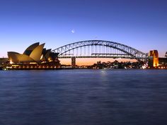 the sydney opera is lit up at night