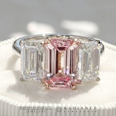 a pink diamond ring with three baguettes on it