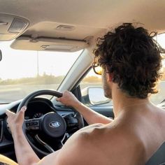 the man is driving his car with no shirt on