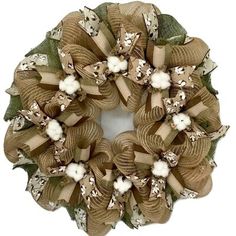 a wreath made out of burlock and fabric with white flowers on it's side