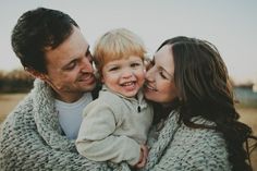 a man, woman and child are smiling at the camera