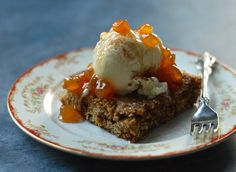 a piece of cake with ice cream and caramel on top sits on a plate