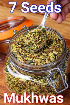 a person spooning seeds into a jar with the words 7 seeds on it and an orange bowl in the background