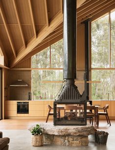 a wood burning stove sitting in the middle of a living room next to a table