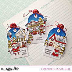 three tags with santa claus on them are hanging from a piece of paper that says happy holidays