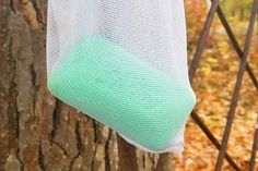 a white mesh bag hanging from a tree