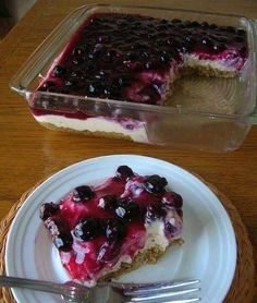 a piece of blueberry cheesecake on a white plate next to a glass dish