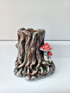 a small mushroom sitting on top of a tree stump next to a red toad house