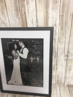 a framed photograph of a couple dancing together in front of a wooden wall with the words,