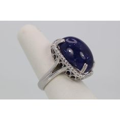 This is part of Chairish’s Fine Jewelry assortment.  WEIGHT: 19.80 grams MAIN STONE: Tanzanite OTHER STONES: Diamonds, 1.25 carats, VVS-SSI clarity, G-H color METAL: 18k white gold SIZE: 6.5 (resizable) CONDITION: New  This Tanzanite Cabochon Diamond Cocktail Ring is impressive as it features a Tanzanite Cabochon weighting in at 34.14 Carats. It has a Diamond surround of 1.25 Carats. This Tanzanite is a gorgeous blue with interesting matrix and is high domed. It is so large you might have to go Oval Diamond Gemstones For Formal Occasions, Formal Oval Diamond Gemstones, Luxury Diamond Gemstones With Cabochon Cut, Luxury Diamond Cabochon Gemstones, Luxury Hallmarked Oval Cabochon Sapphire Ring, Formal Polished Finish Oval Cabochon Sapphire Ring, Luxury Oval Cabochon Diamond Gemstones, Oval Center Stone Gemstones For Formal Occasions, Oval Gemstones With Halo Setting For Formal Occasions