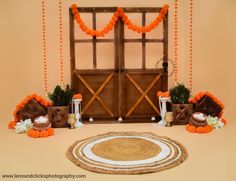 an orange and white wedding set up in front of a barn door with pumpkins