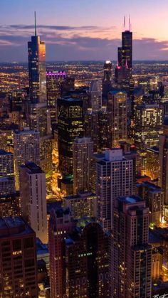 the city lights shine brightly at night in this aerial view from above, with skyscrapers and other high rise buildings