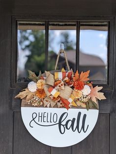 a welcome sign hanging on the side of a door that says hello fall with flowers and leaves