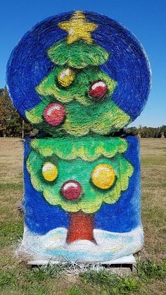 two christmas trees made out of yarn sitting on top of each other in a field