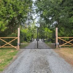 a gated driveway leading into a wooded area