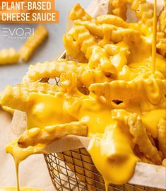 cheesy cheese sauce being drizzled onto french fries in a basket