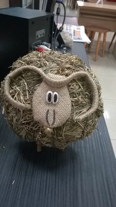 an animal made out of hay sitting on top of a table