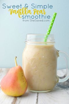 a smoothie in a mason jar next to a pear