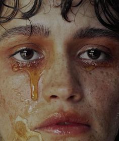 a young man with freckles on his face and eyes covered in brown substance