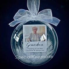 a glass ornament with an image of grandma on it and a ribbon around the edge