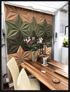 a wooden table topped with two vases filled with flowers next to a wall mural