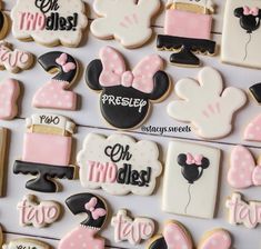 some decorated cookies with minnie mouse and other items on them, all in pink and black