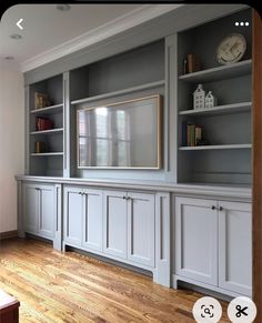 a living room with built in bookshelves and cabinets