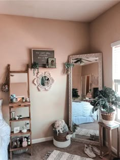 a bedroom with a mirror, shelf and plant on the floor in front of it