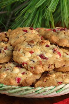 cookies are stacked on top of each other in a bowl next to a christmas tree