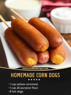 three corn dogs on a white plate with toothpicks