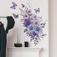 a white fireplace with purple and blue flowers on it next to a wall mural that has butterflies flying over the fire place