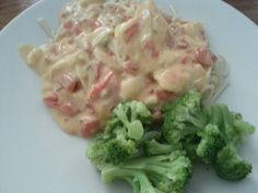 broccoli and pasta on a white plate with gravy in the middle