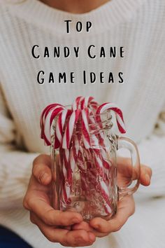 a person holding a glass mug with candy canes in it and the words top candy cane game ideas