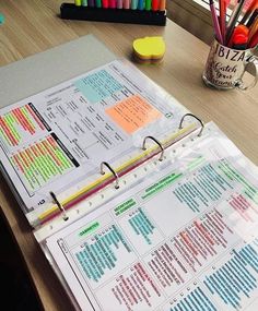 a binder that is sitting on a desk next to some pens and pencils