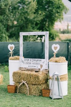 hay bales stacked on top of each other in front of a wooden frame and sign