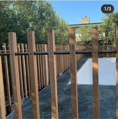 a wooden fence surrounding a pool surrounded by trees