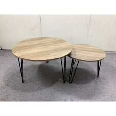 two round tables with hairpin legs on carpeted floor in front of white wall