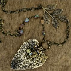 Patina Jewelry, Patina Pendant, Brass Leaf Necklace, Vintage Jewelry, Rustic Leaf Necklace, Beaded Leaf Necklace, Statement Necklace Handmade leaf focal is 100% made in the USA nickel-free brass & done in a hand applied brass ox patina. The components are not plated but rather hand oxidized to give each piece that one-of-a-kind weathered metal rustic appearance. Accented with Czechoslovakian crystal beads & a dragonfly charm. Chain is 20 inches long, not counting the leaf focal. -------- Bohemian Metal Necklaces With Faceted Beads, Bohemian Metal Necklace With Faceted Beads, Bohemian Necklace With Faceted Metal Beads, Patina Jewelry, Jewelry Rustic, Art Ring, Beaded Leaf, Dragonfly Charm, Charm Chain