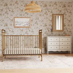 a baby crib and dresser in a room with floral wallpaper on the walls