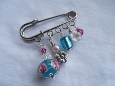 a close up of a brooch with beads and charms