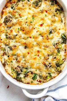 a casserole dish with broccoli, cheese and other toppings in it