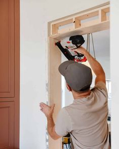 a man is working on an unfinished door frame