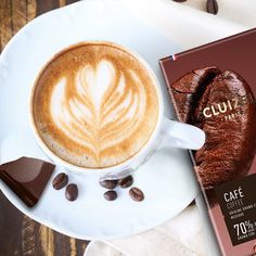 a cappuccino on a plate next to a chocolate bar