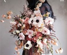 a woman holding a bouquet of flowers in her hands