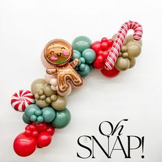 an assortment of balloons are arranged in the shape of a gingerbread man and candy canes