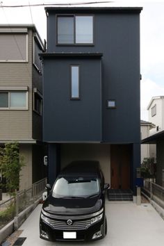 a black car parked in front of a two story house