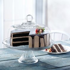 a chocolate cake on a glass plate with a slice missing