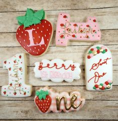 decorated cookies with the words 1st birthday and one strawberry on them are arranged next to each other