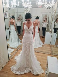 a woman is looking at her wedding dress in the mirror